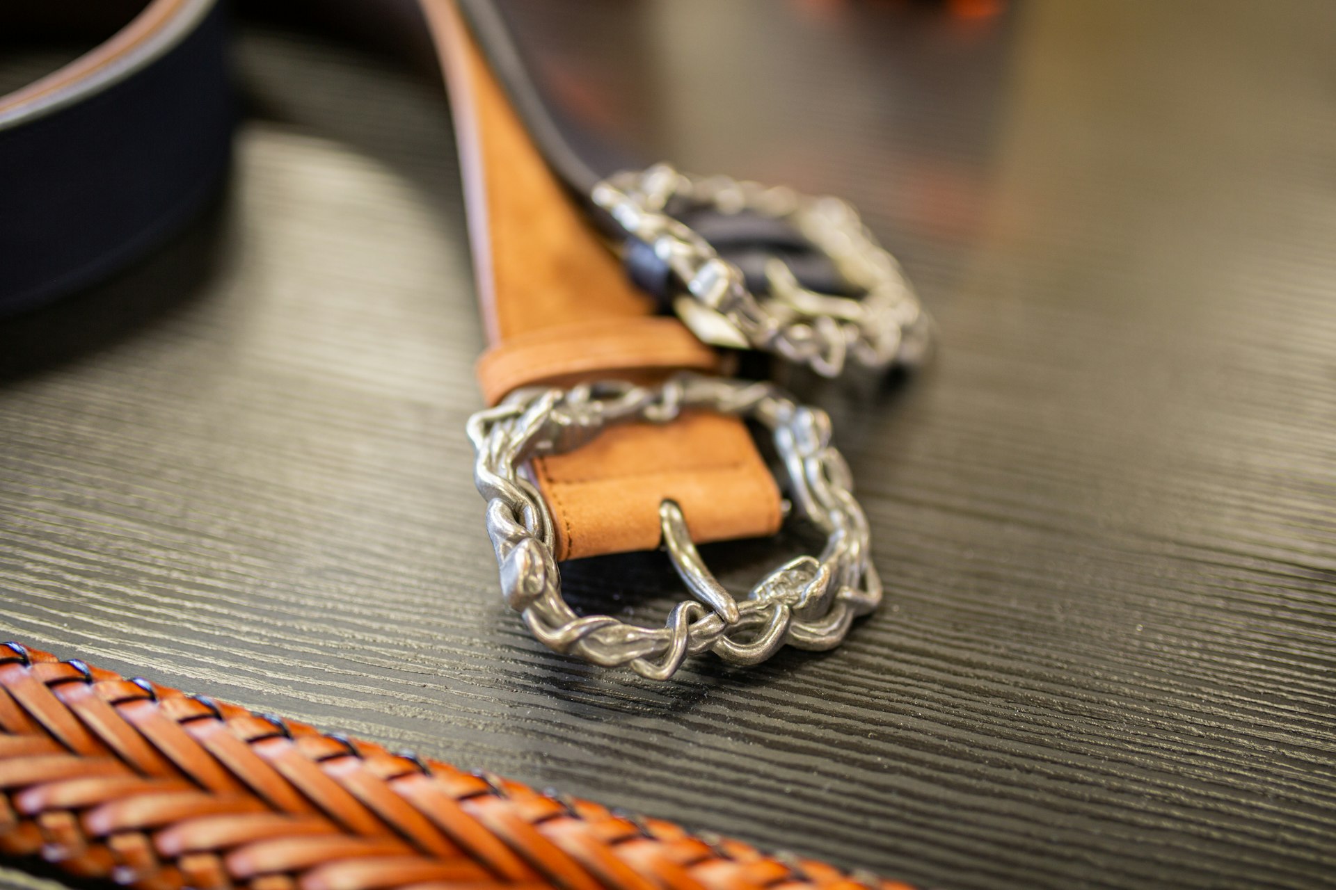 A pair of leather belts sitting on top of a table